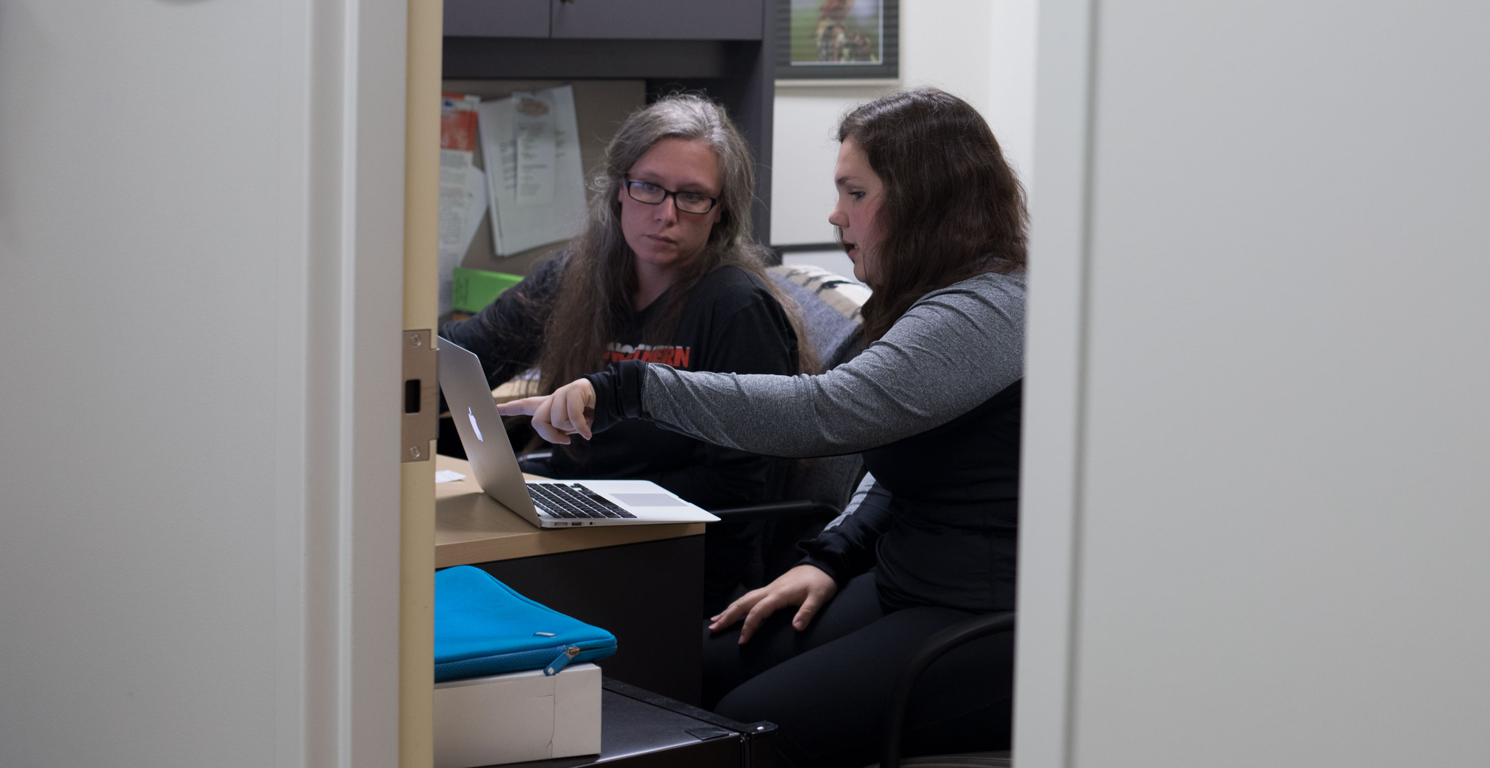 Biology professor helping student in her office.