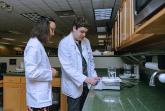Ryan Waldschmidt, a CPESN Ohio resident, assists Ohio Northern University pharmacy student Ruth Lim with a compounding procedure