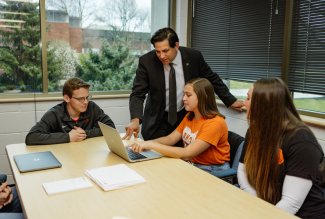 Ohio Northern University Professor Robert Alexander, Ph.D., looking at data with three political science students.