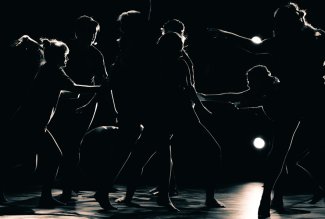 Dancers in silhouette rehearsing for IMPULSE: A Spring Dance Concert.