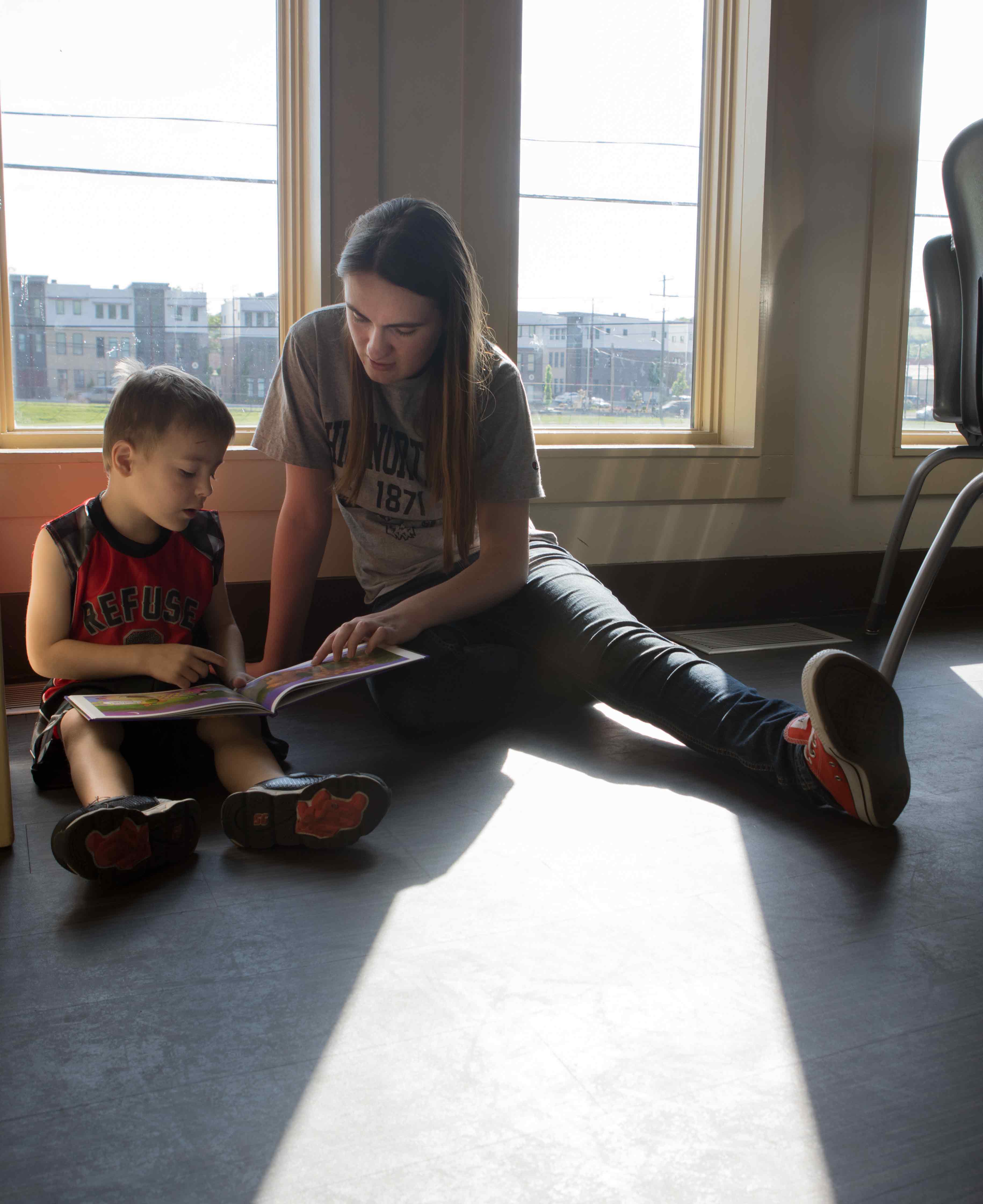 education student reading to kid