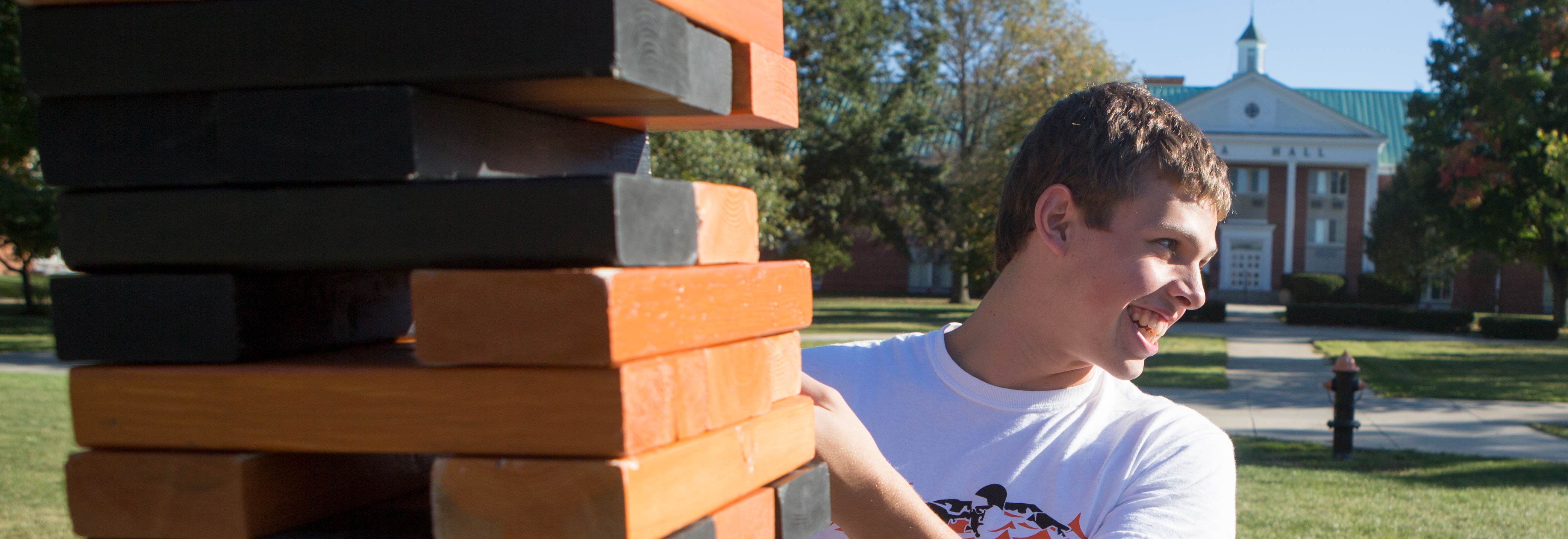 Student plays Jenga outside Lima Hall