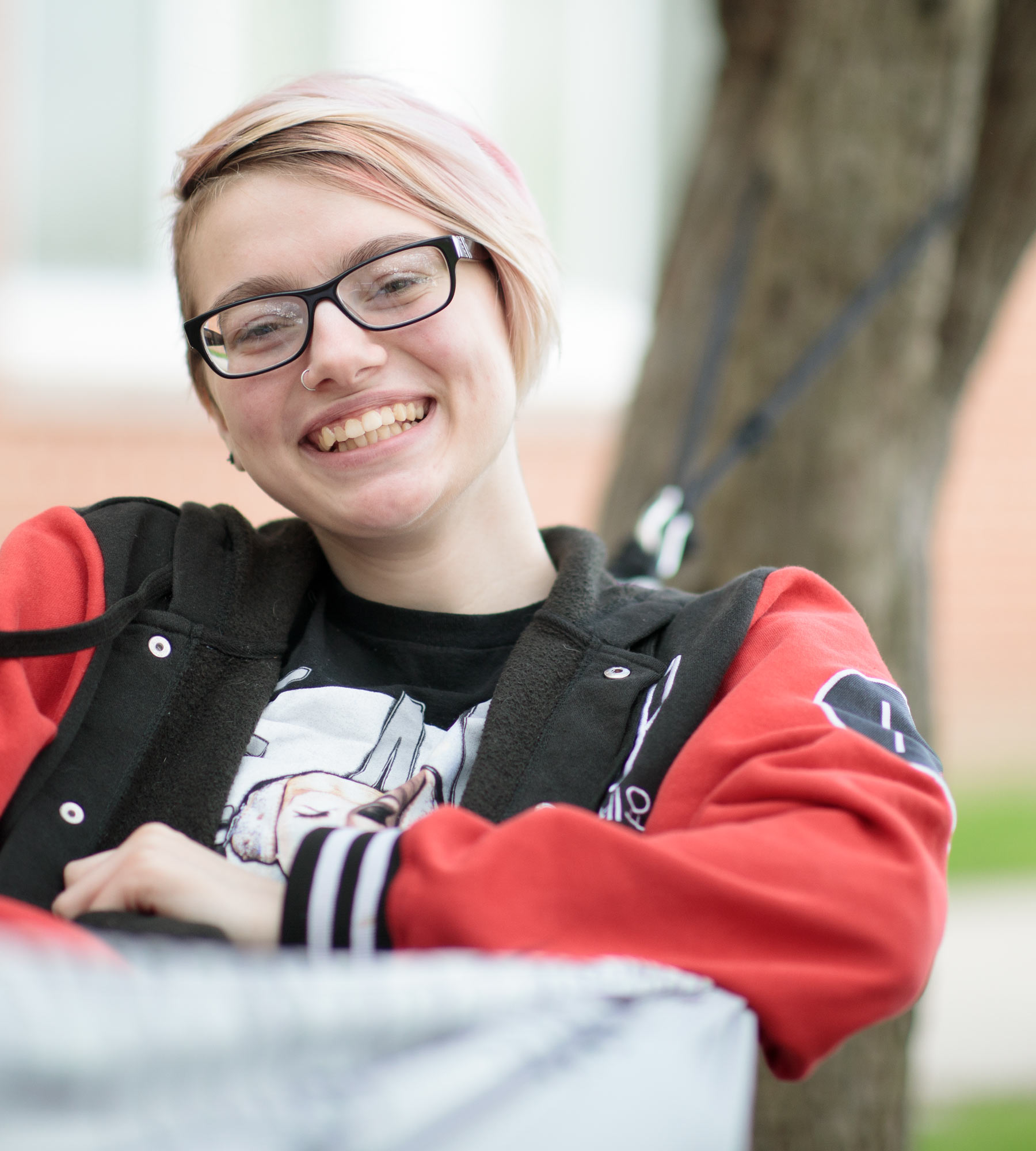 Student sits in a hammock outside of Founders Hall