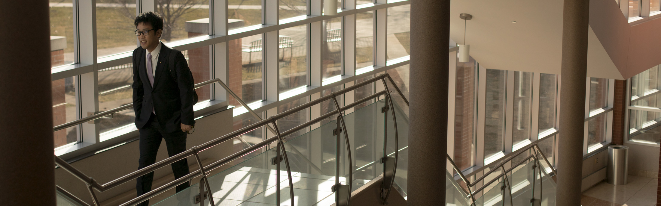 student walking up the stairs in the Dicke College of Business.