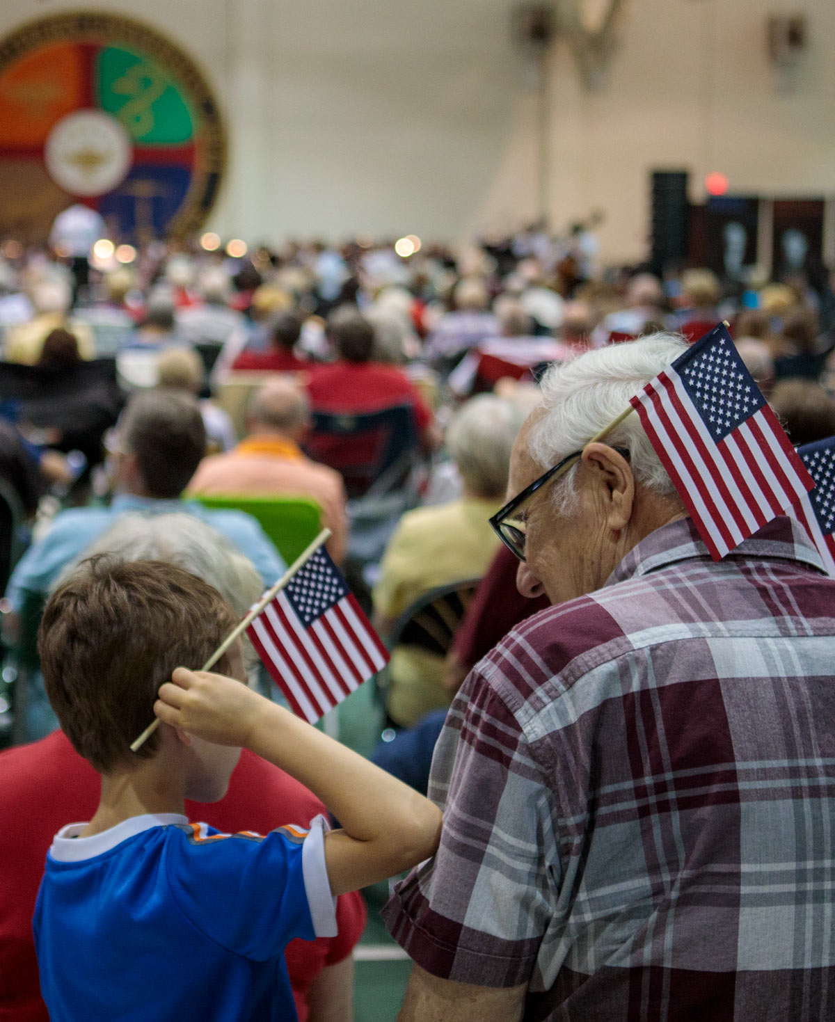 Grandson sits with his grandfather during the patriotic pops concert.