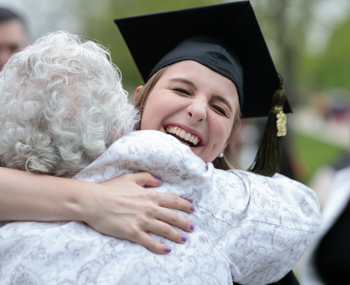 Pharmacy student hugs family member following the ceremony