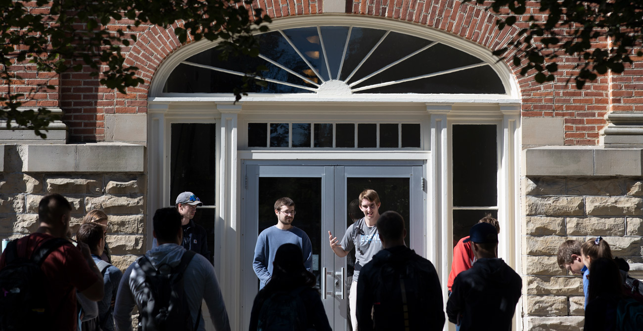 Students deliver presentations during class outside.