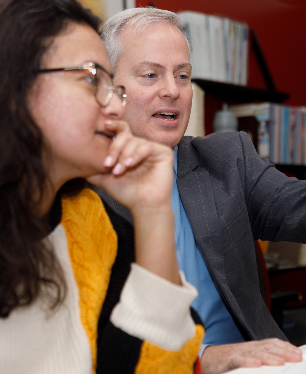 Professor of Graphic Design works with a student in the computer lab.