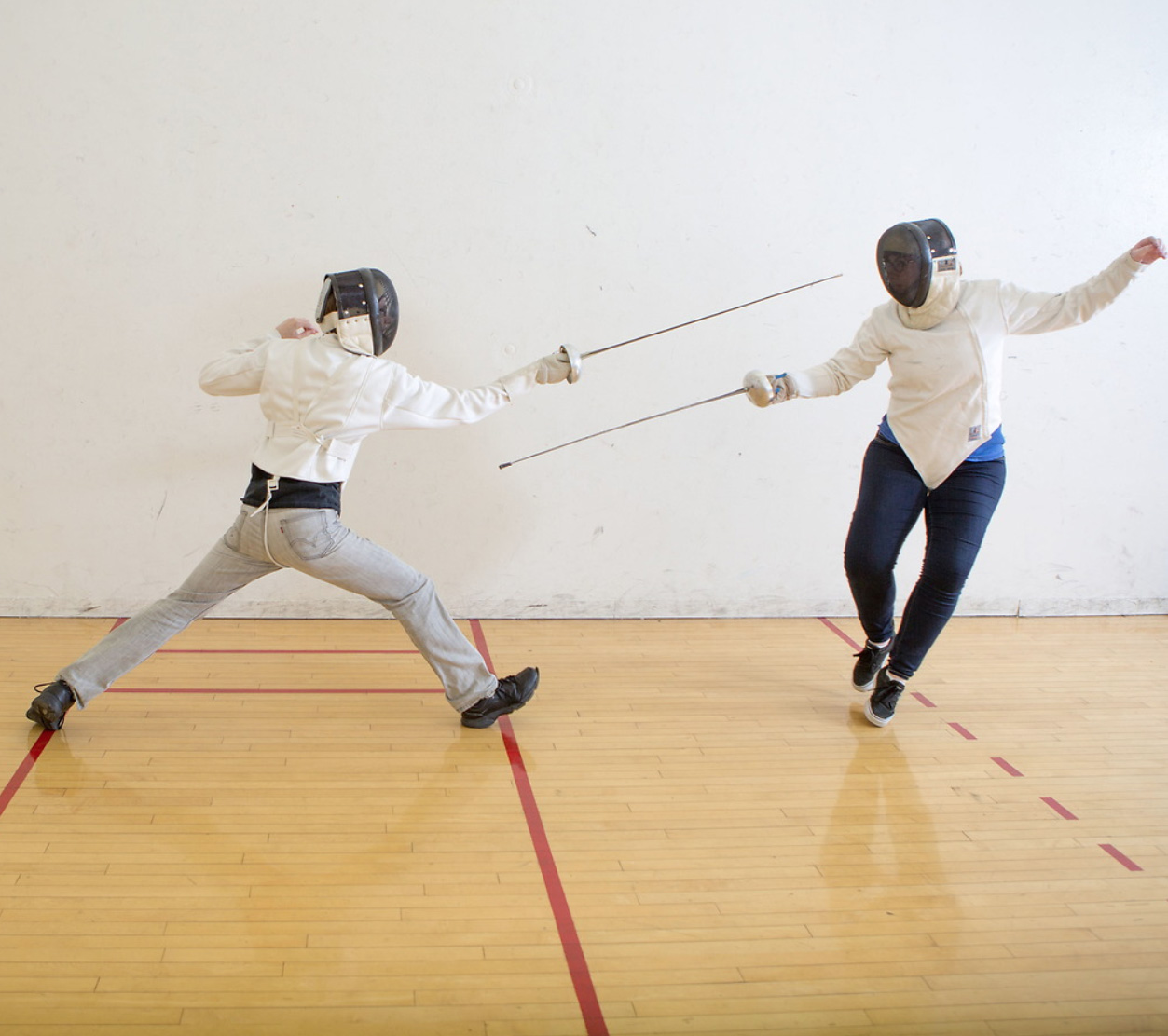 Two students working on drills during fencing practice