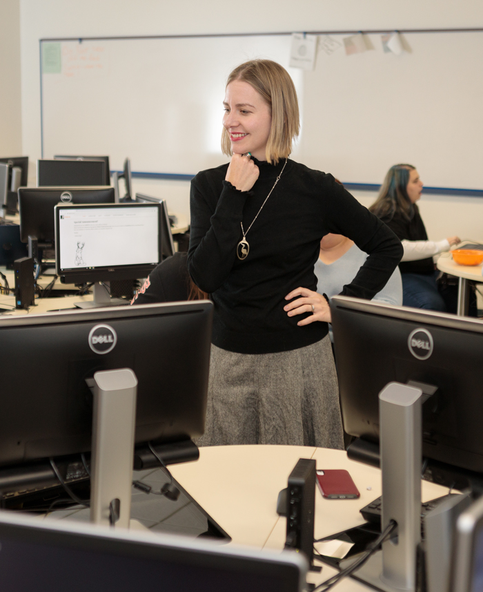 professor works with students in the computer lab.