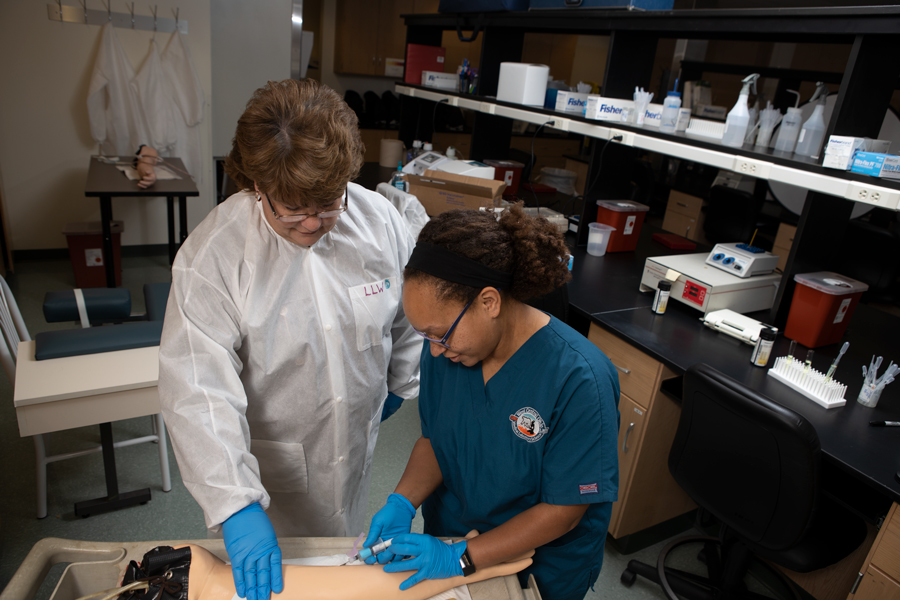 medical laboratory science students work in the classroom with the professor.