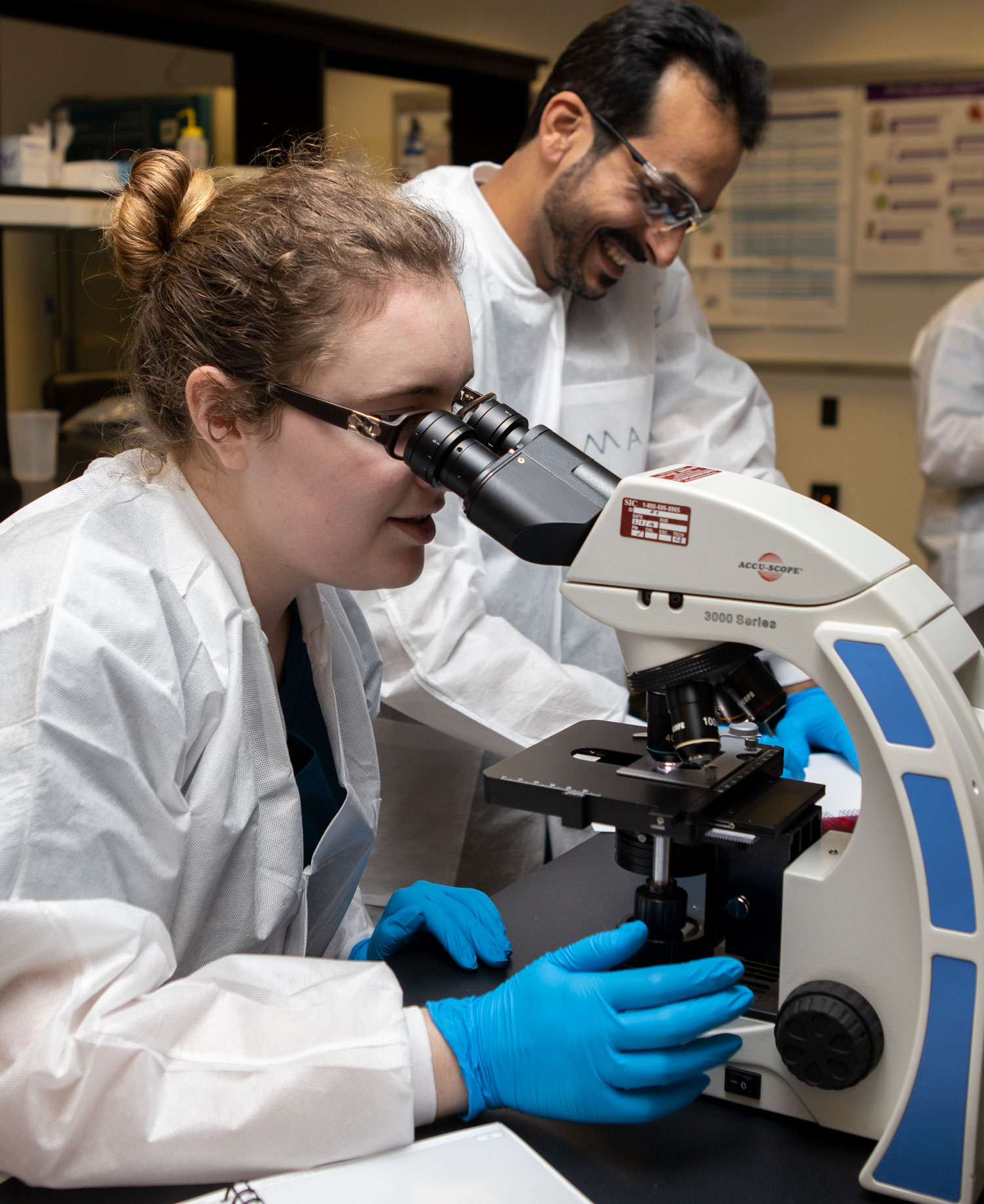 students looking though a microscope during a lab. 