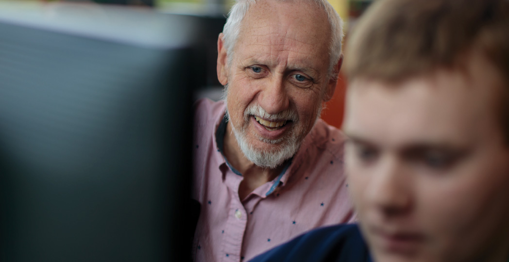 Teacher and student around a computer