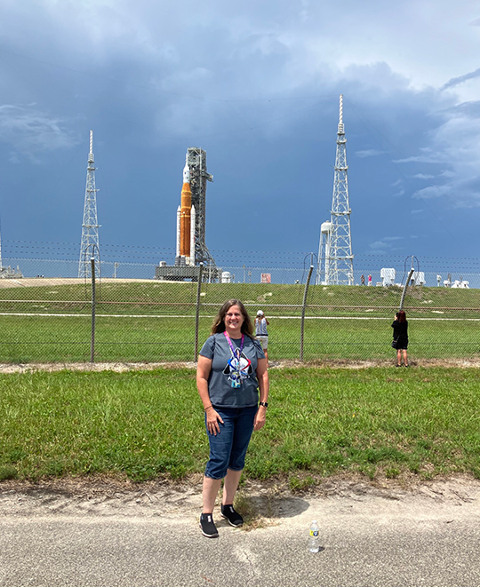 Artemis rocket photo with Coleen Withrow posing in front of it