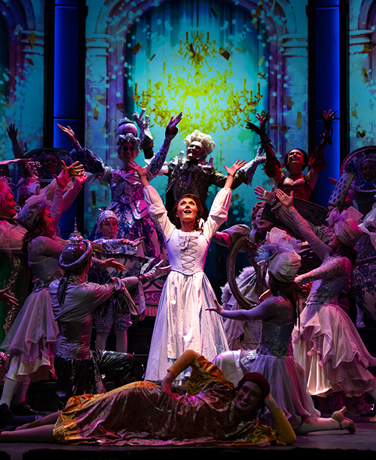 Students perform on stage during a rehearsal of Beauty and the Beast