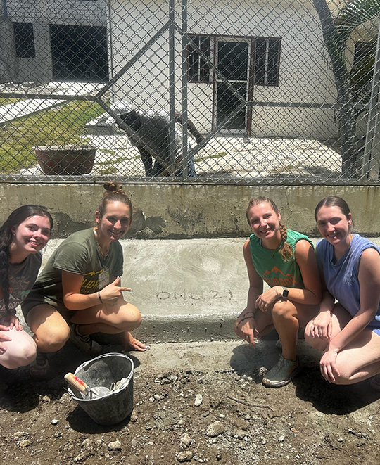 Photo of ONU students helping pour concrete curbs