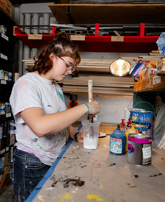 Theater Production Student mixing up a compound