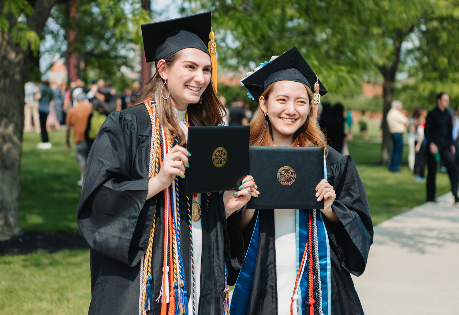 student holding their new degrees on graduation day