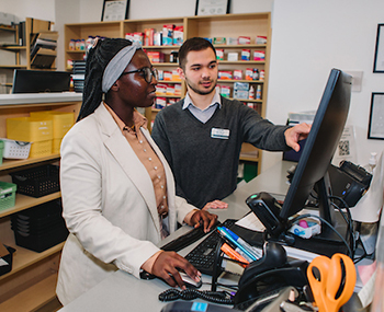 Photo of Pharmacy students looking at a monitor
