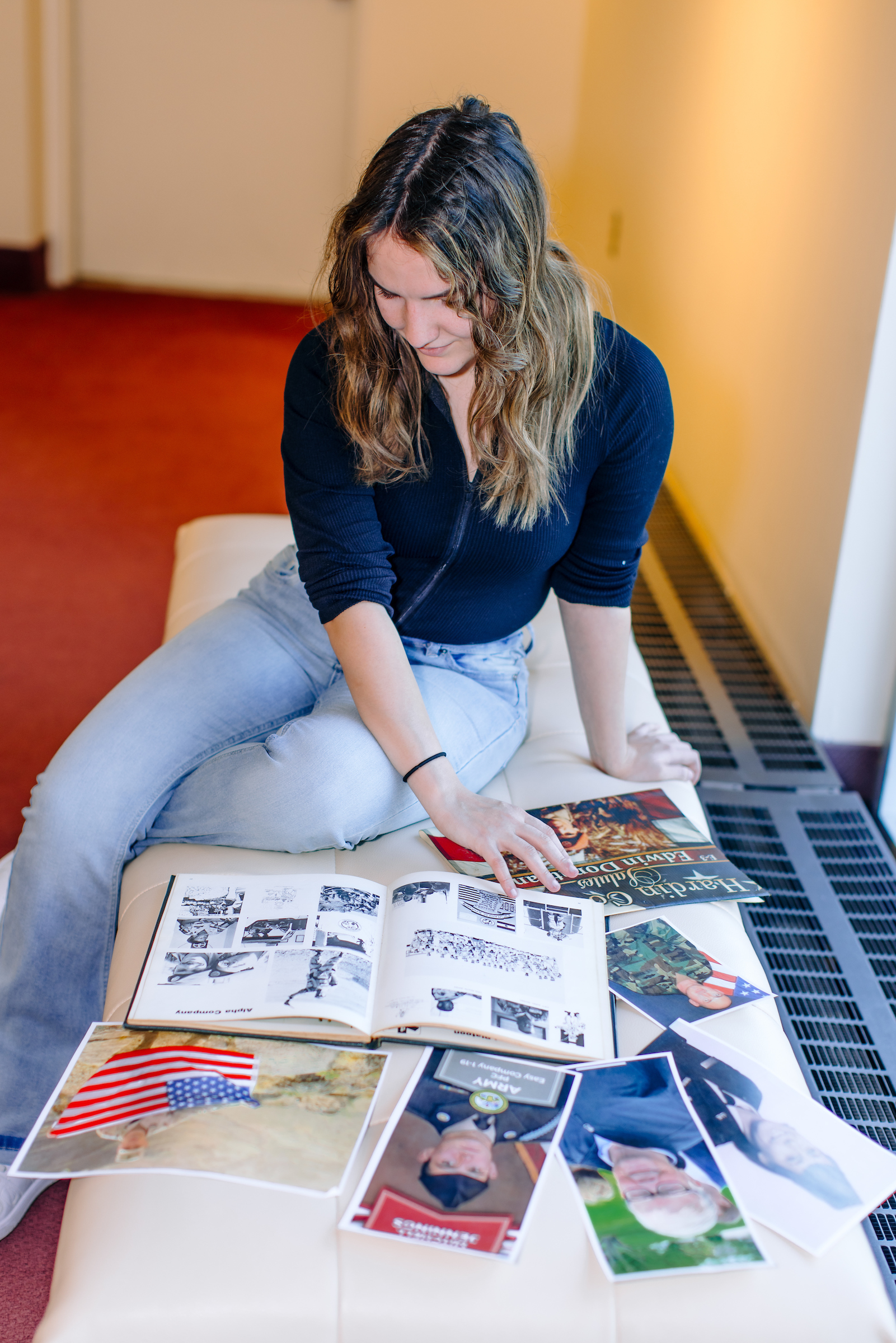 Photo of Archer looking at army/navy photos on her bed 2