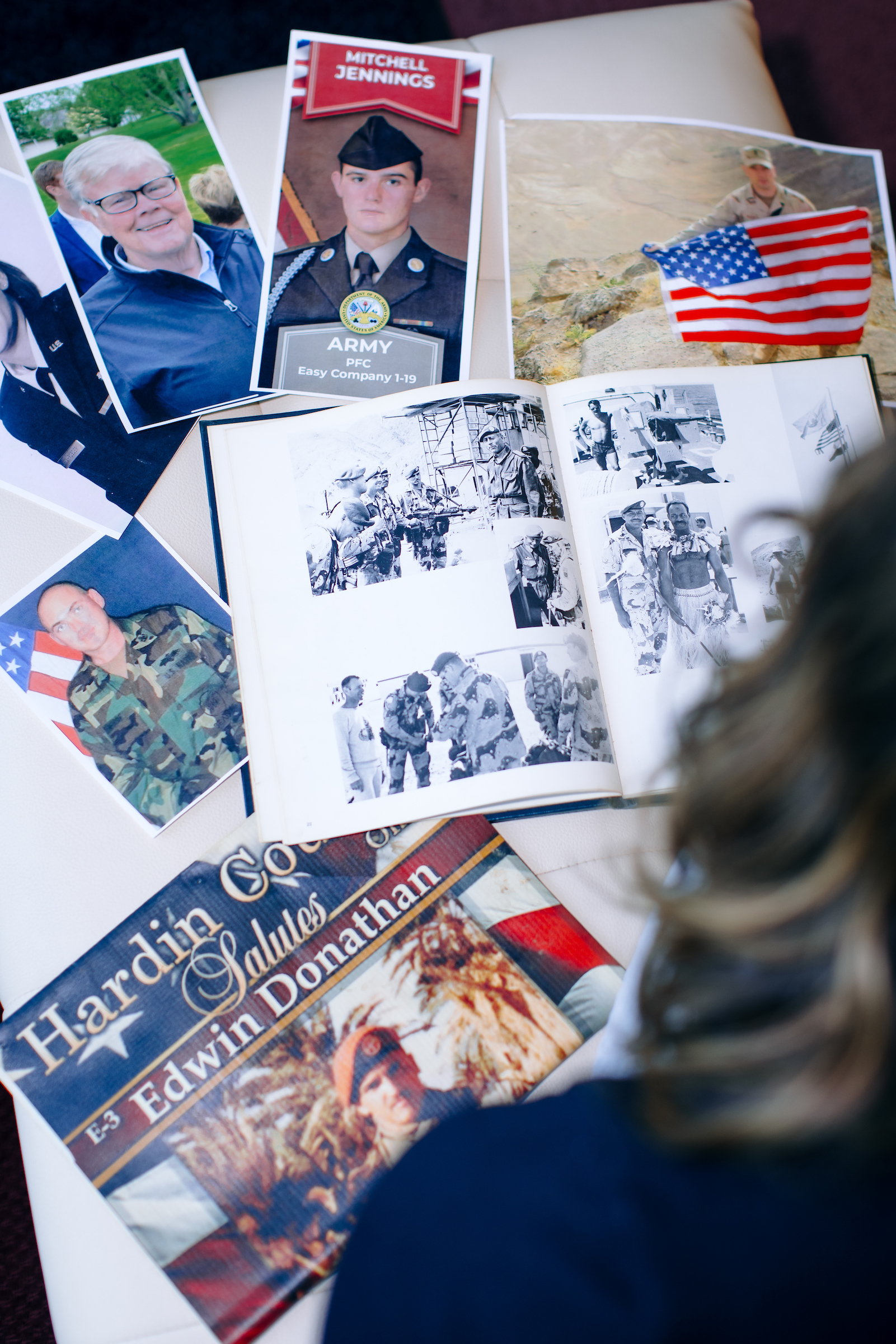Photo of Archer looking at army/navy photos on her bed