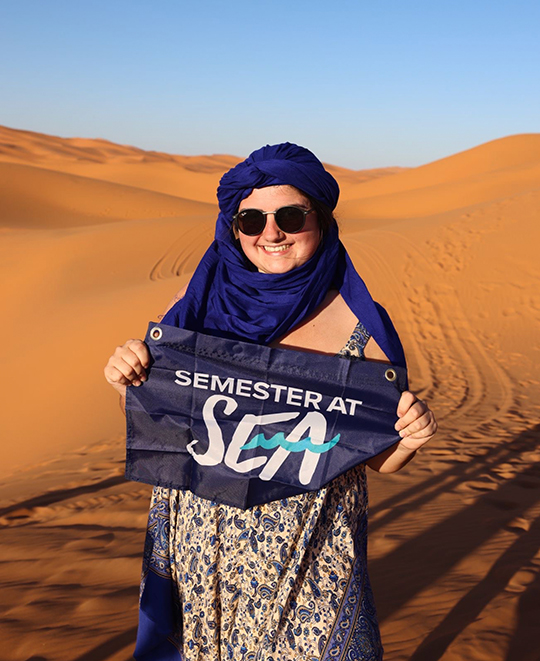 Photo of Mallory holding a semester at sea sign