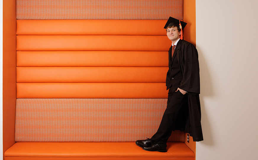 Photo of Jacob Reed posing with an orange background