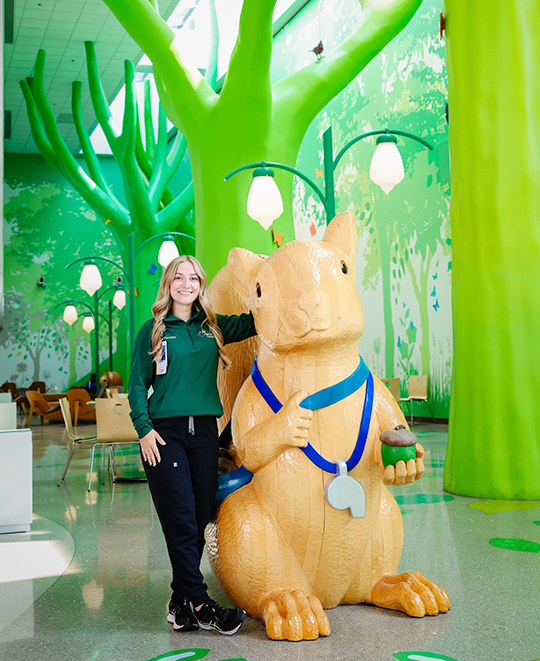 Photo of Ashly posing next to a giant chipmunk statue