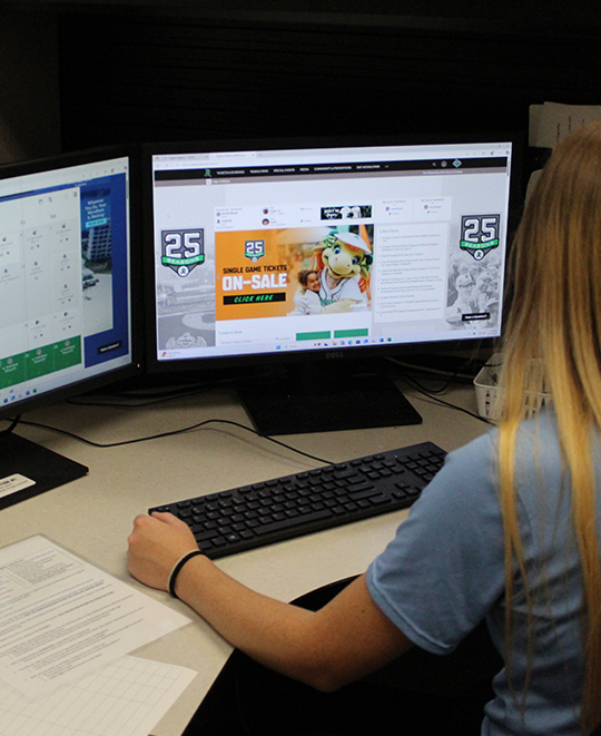 Photo of Chloe sitting at a desk working on her computer
