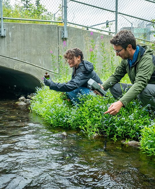 Photo of Elizabeth and someone else about to take water samples