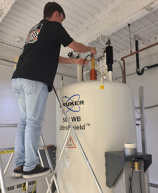 Photo of Max in loading a nuclear magnetic resonance spectroscopy magnet