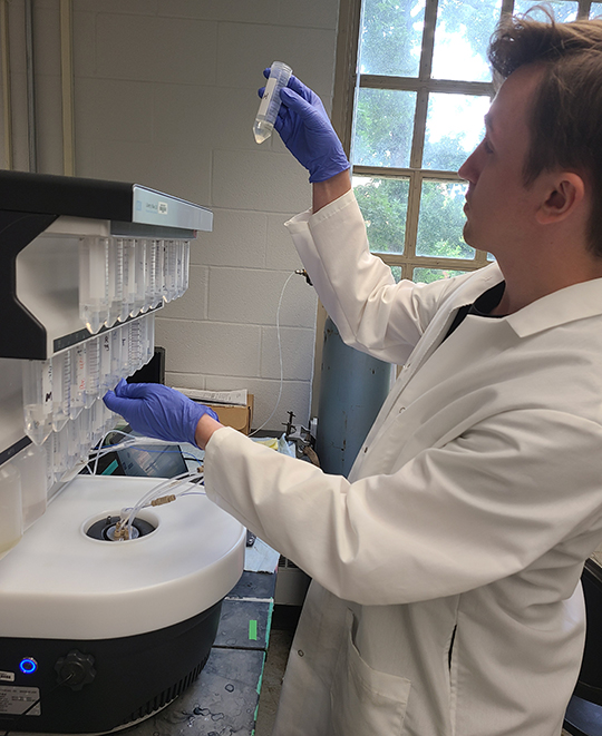 Photo of Max holding samples in the air to take a closer look