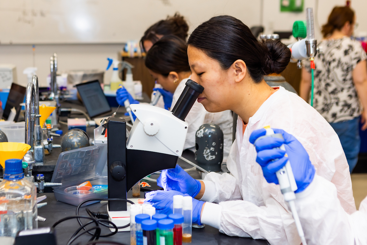 student looking into a microscope