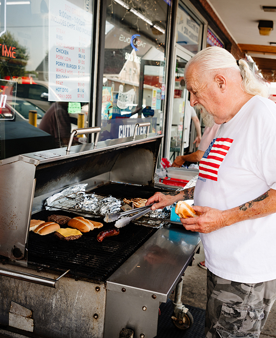 Photo from Carryout Restaurant, restaurant worker manning the grill