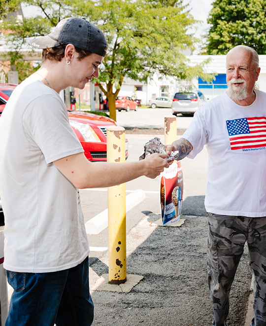 Photo from Carryout Restaurant, restaurant worker handing patron his ordered food