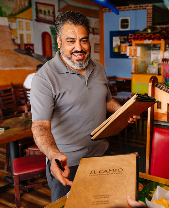 Photo from El Campo Restaurant, waiter collecting menus from table