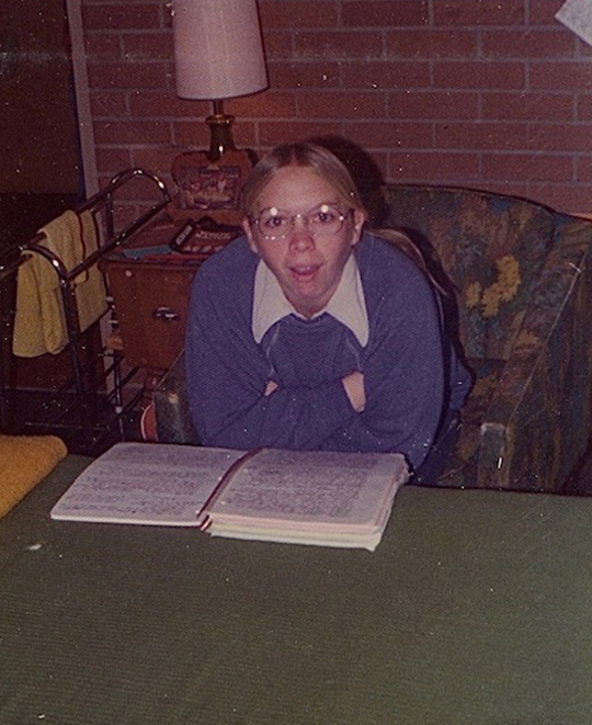 Old Photo of ONU student seated in a sofa chair with her notes in front studying.