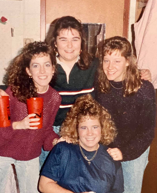Photo of 4 of the ladies posing together in their college days