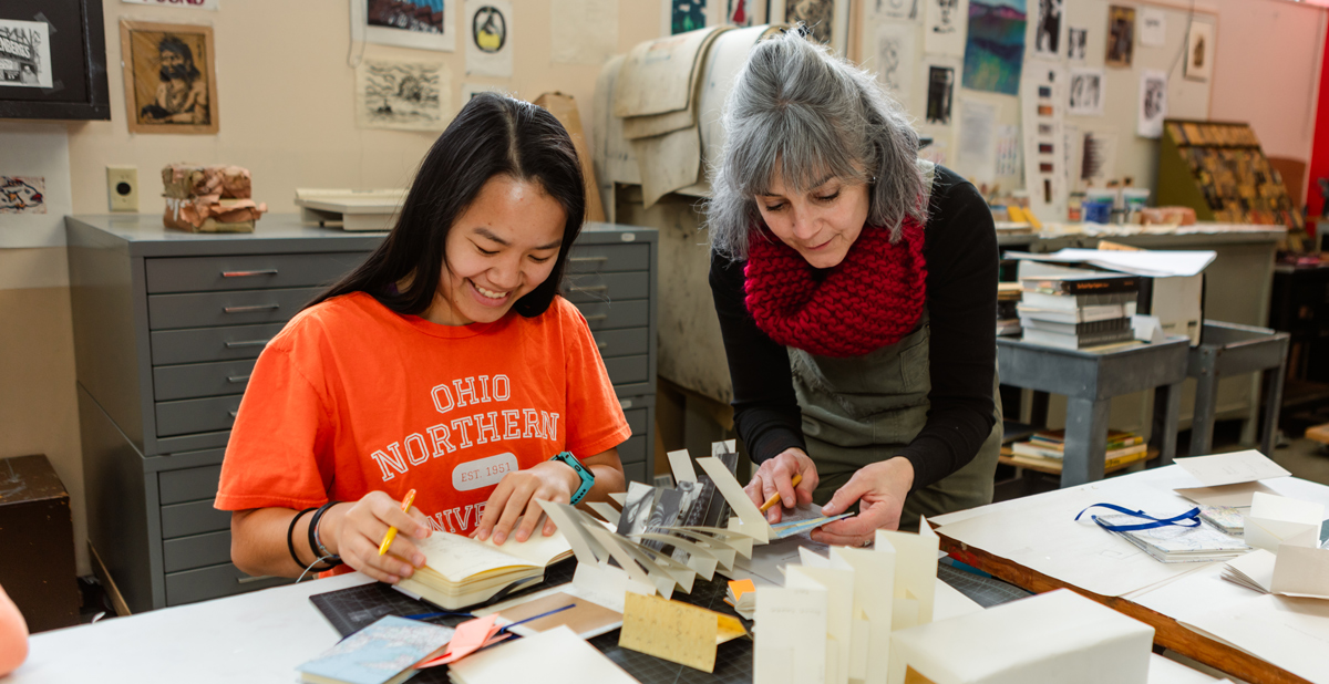 Art and design professor helping a student on a project