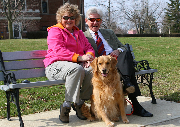 Photo of Kendall with with his wife sitting on a bench 