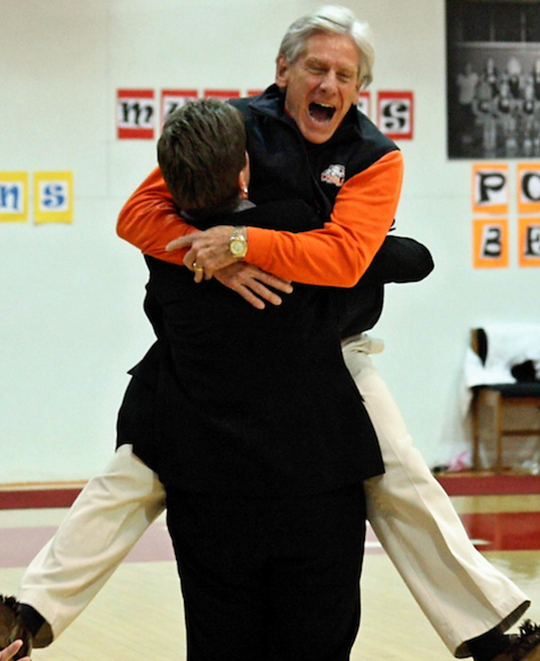 Photo of Baker being lifted up in an embrace