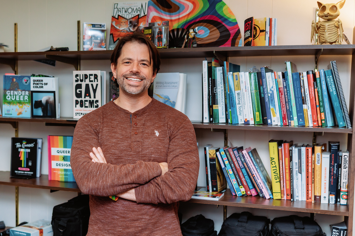 Bryan Lutz posing next to his books