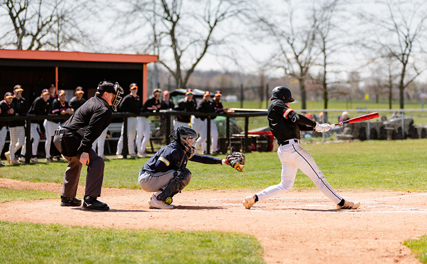 Photo from a baseball game of ONU student athlete hitting a ball