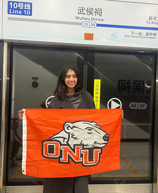 Female student in China tram holding an orange ONU flag with a polar bear