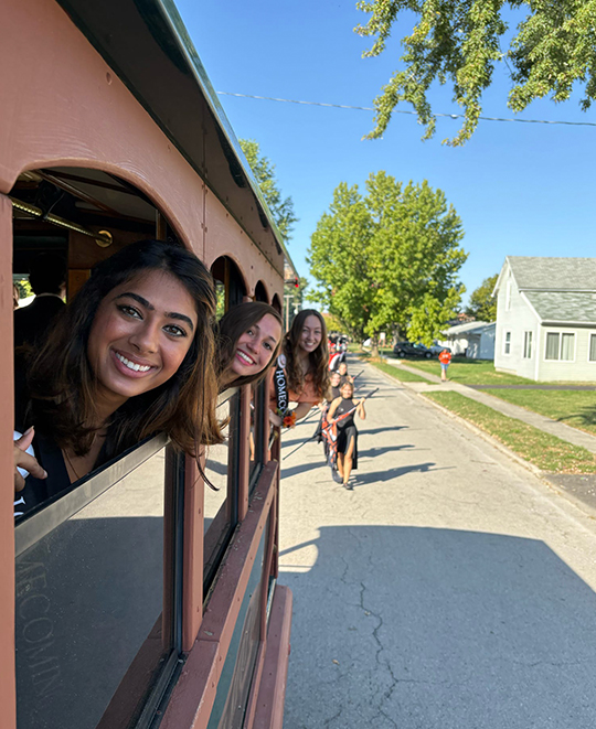 homecoming court with their heads out of the tram