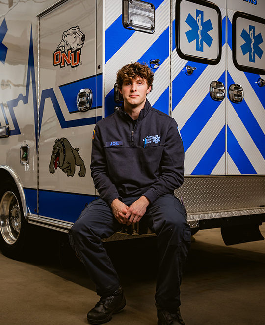 Joey seated on the bumper of the EMS