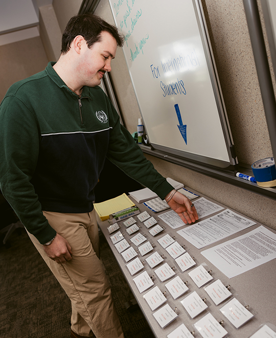 Justin looking down at a table with documents and note cards