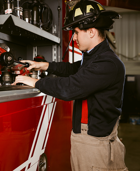 Michael with his fireman hat checking the fire truck gear