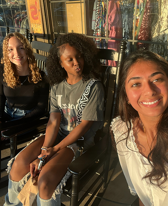 Rocking chair selfie with 3 ladies posing, one making a kissy face