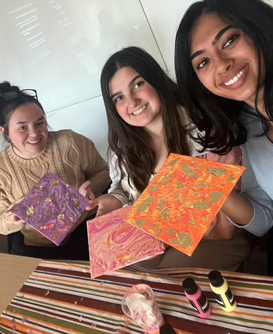 Painting party selfie with 3 friends showing their works of art